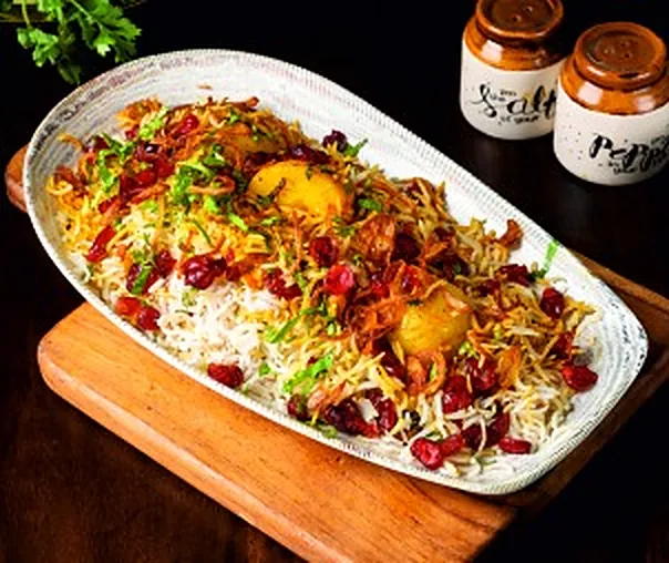 Berry pulao topped with barberries, fried onions and eggs
